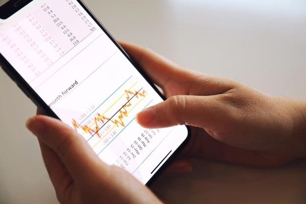 A close-up shot of a person's hands using a smartphone to track income and expenses, with charts and graphs displayed on the screen. The image emphasizes the use of technology for financial management.