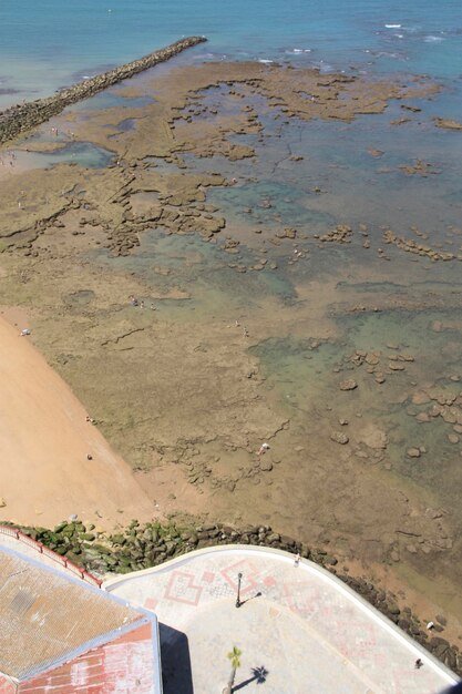 An aerial view of a coastline showing areas of erosion and properties at risk from rising sea levels and coastal flooding. The image highlights the geographical vulnerability of coastal communities.