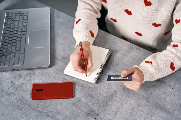 A person using a laptop, looking at different credit card offers and interest rates, with a calculator and pen nearby, conveying the idea of comparing and calculating financial options.
