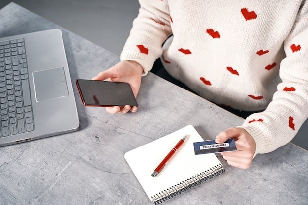 A hand holding a credit card in front of a laptop displaying credit card statements, illustrating the process of reviewing and calculating credit card debt.