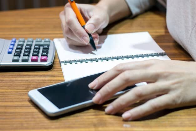 A person using a calculator and a pen to write down numbers on a notepad, with a credit card and a loan application form placed nearby, representing debt consolidation calculations and options.