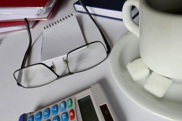 Close-up of a pile of medical bills with a calculator, glasses, and a pen on top, symbolizing financial stress and planning.