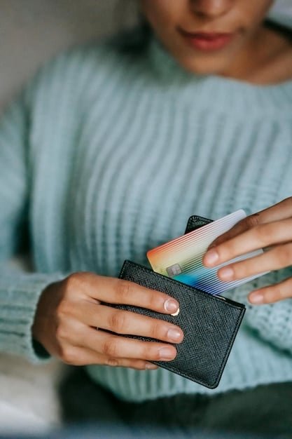 A close-up shot of a hand holding a credit card, blurred background of bills and financial statements illustrating everyday financial stress.