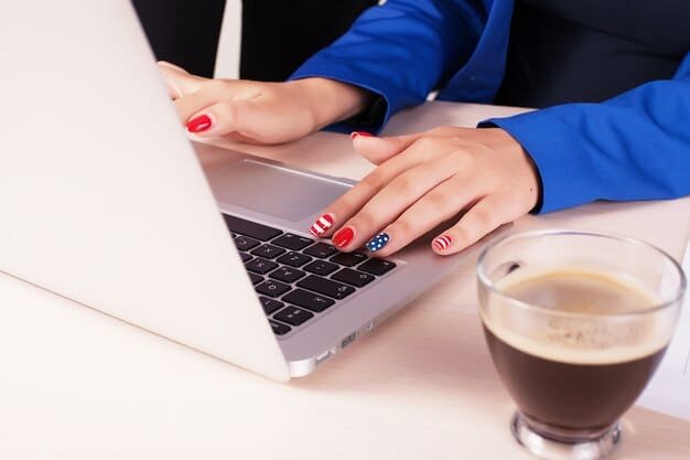 A close-up shot of hands typing on a laptop keyboard, focusing on the act of applying for unemployment benefits online. The screen shows a state unemployment agency website with application forms.