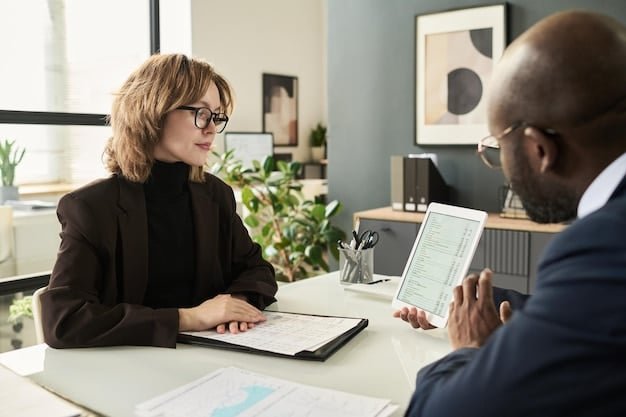 A credit counselor sitting across a desk from a client, both looking at a financial document together. The setting is a professional office environment.
